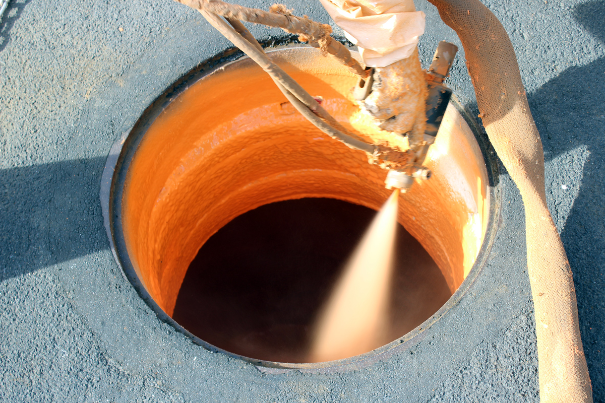 Manhole rehabilitation expert at work inside a manhole